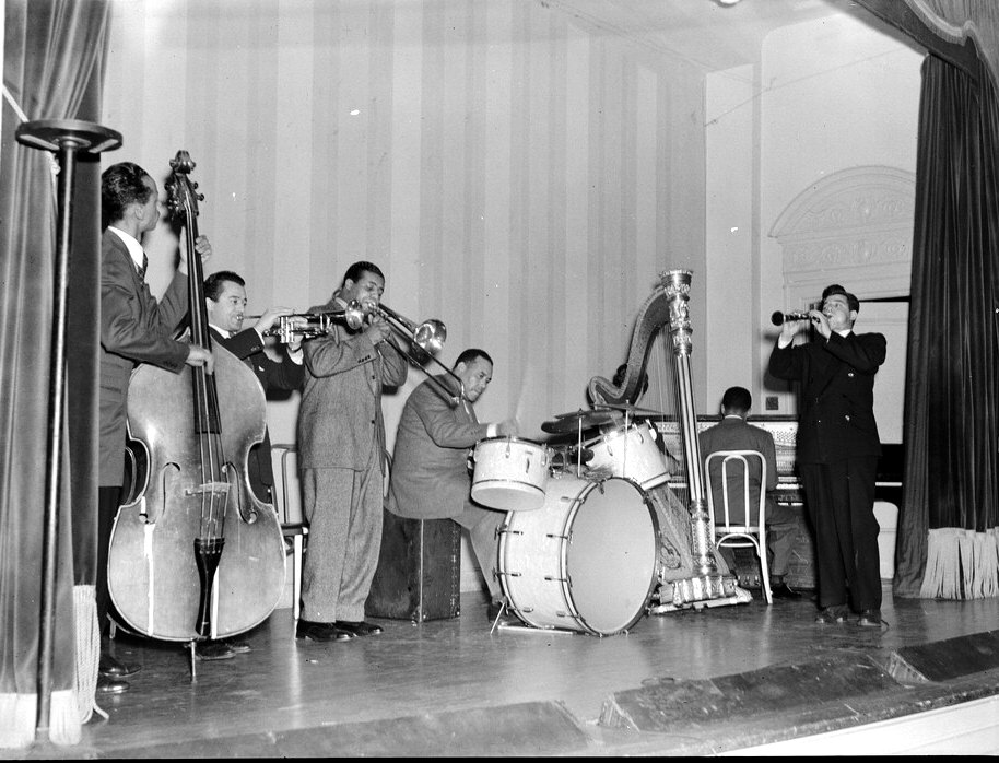 A 1939 jam session: a double bass, trumpet, trombone, drums and a clarinet player spread across a stage.